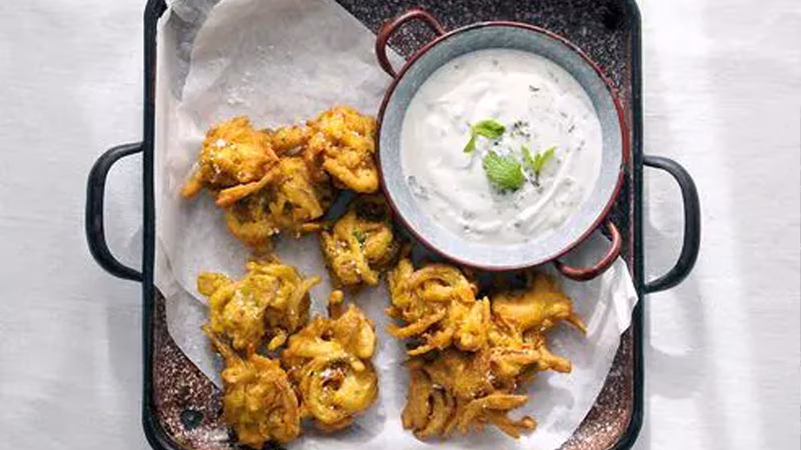 Recette : Bhajis d’oignons rouges et raïta à l’ail