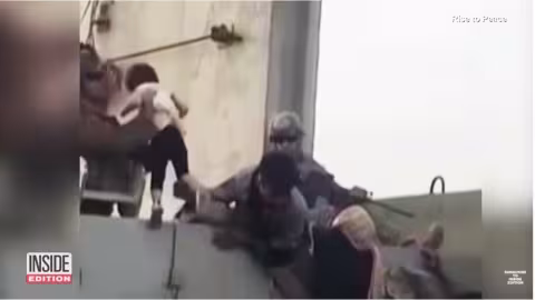 Une jeune fille remise à un soldat américain sur le mur de  l’aéroport de Kaboul